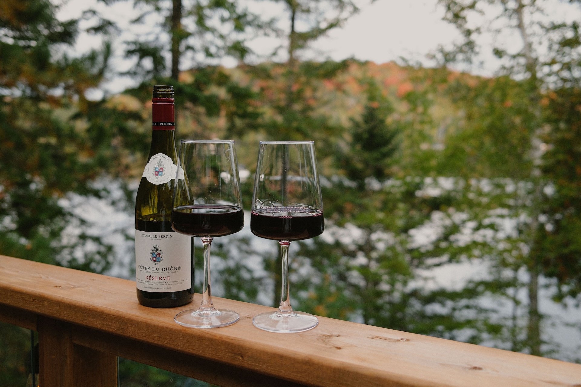 Wine glasses on the deck railing overlooking the lake